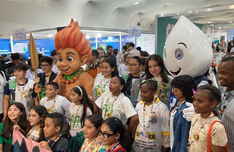 Fabíola Sinimbú/Agência Brasil Brasília (DF) 17/11/2025 – Os mascotes Curupira e Zé Gotinha, com uma meninas da Tanzânia.
Foto: Fabíola Sinimbú/Agência Brasil