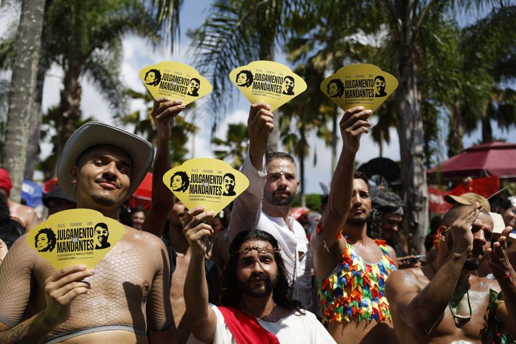Fernando Frazão/Agência Brasil Rio de Janeiro (RJ), 15/02/2026 – Foliões recebem leques alusivos ao julgamento dos mandantes do assassitato de Marielle Franco e Anderson Gomes no bloco Divinas Tretas, que atrai público LGBTQIAPN+ no Aterro do Flamengo. Foto: Fernando Frazão/Agência Brasil