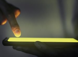 mao-tocando-a-tela-iluminada-do-smartphone.jpg